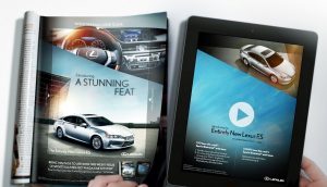 A magazine with a car advertisement in it with a tablet next to it with the same ad on the screen