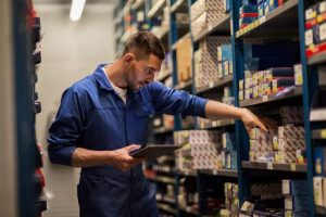 Male worker organizing inventory boxes in a warehouse
