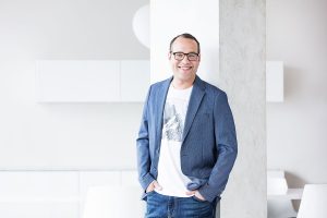 Smiling man leaning on pillar