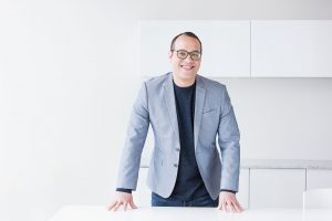 smiling man with hands on table