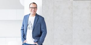 Male marketing consultant standing up and smiling in a blue suit