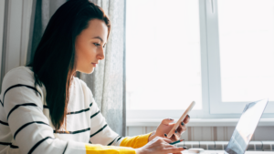 woman calculating something on her phone and computer